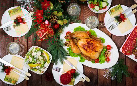 Baked turkey or chicken. The Christmas table is served with a turkey, decorated with bright tinsel and candles. Fried chicken, table. Christmas dinner. Flat lay. Top view photo