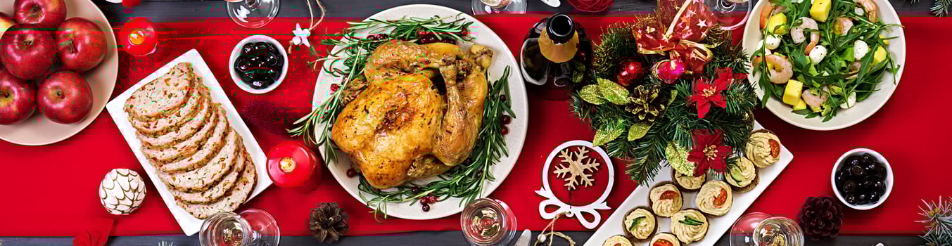 Baked turkey. Christmas dinner. The Christmas table is served with a turkey, decorated with bright tinsel and candles. Fried chicken, table.  Family dinner. Top view photo