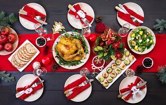 Baked turkey. Christmas dinner. The Christmas table is served with a turkey, decorated with bright tinsel and candles. Fried chicken, table.  Family dinner. Top view photo