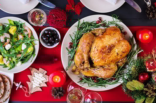 Baked turkey. Christmas dinner. The Christmas table is served with a turkey, decorated with bright tinsel and candles. Fried chicken, table.  Family dinner. Top view photo