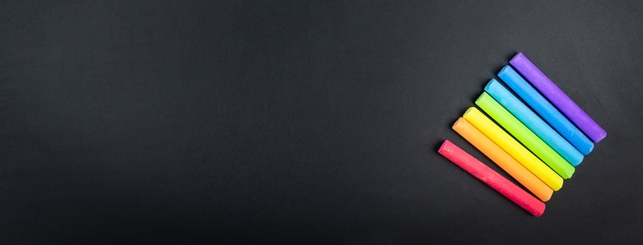Multicoloured chalk on blackboard background photo