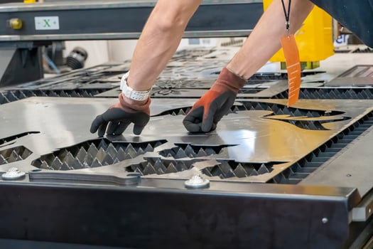 laser cutting machine, cutting wood sheets, while a man takes care of the process, latin america photo