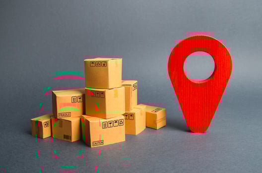 A pile of cardboard boxes and a red position pin. Locating packages and goods. Algorithm for constructing a minimum route for the delivery of orders. Tracking parcels via the Internet. photo