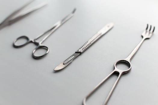 Steel scalpel with medical tools on a white table. photo