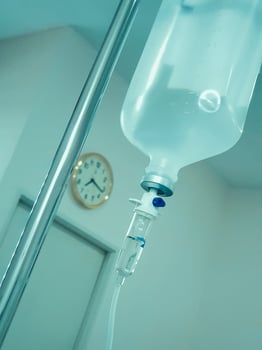 new saline bottle hanging in patient's room photo