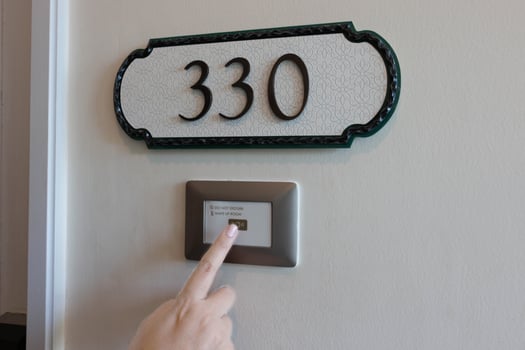 finger pressing on electronic doorbell photo