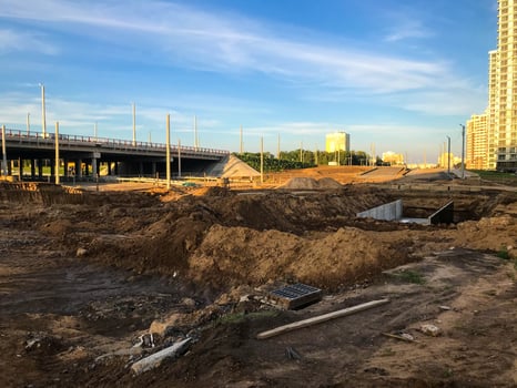 construction site with sand and water. rubbish, building materials, mud puddles lie nearby. construction materials and spare parts lie next to the bridge. construction of a new district photo