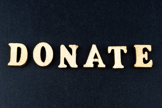 The word donate made from wooden cubes. Conceptual photo. Top view photo