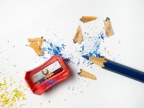 School supplies. Pencil sharpening.   Multicolored pencils on a white background. Wood shavings. The process of preparing for work. Creative mess photo