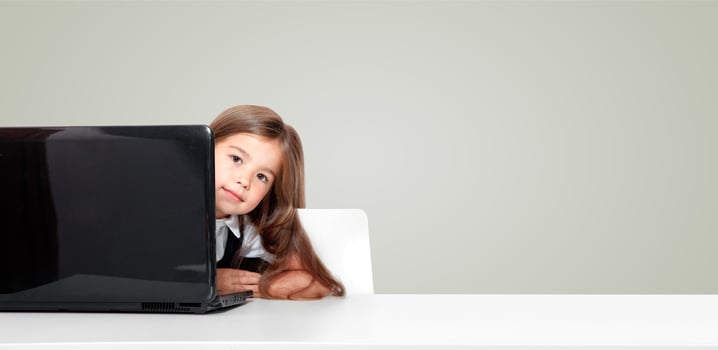 Happy and cute teen school girl sitting on laptop photo