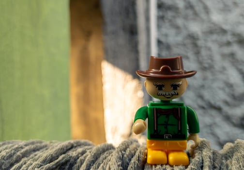 October 2022, Jakarta Indonesia, minifigure toy against a background of a blurred wall and a wooden fence in the sun photo