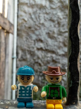 October 2022, Jakarta Indonesia, minifigure toy against a background of a blurred wall and a wooden fence in the sun photo
