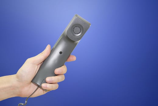 Hand holding telephone receiver photo