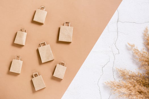 Craft paper shopping bags on a two-tone background. Sustainable lifestyle. Top view. photo