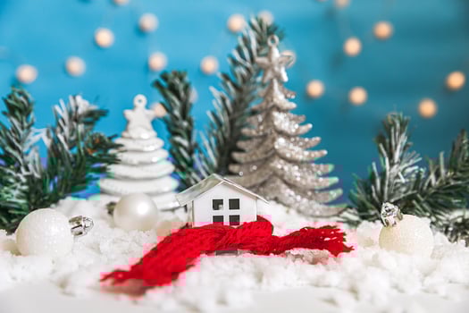 Abstract Advent Christmas Background. Toy house with knitted scarf with snow and winter decorations ornaments on blue background. Christmas with family at home concept. photo