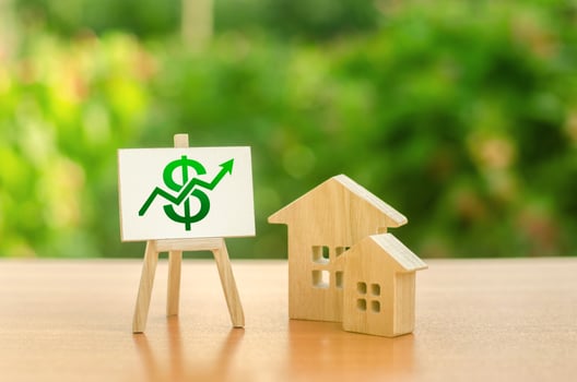 Two wooden houses and a green up arrow on the sign. Real estate value increase. Rising prices for housing, building maintenance. Supply and demand. High rates of construction, high liquidity. photo