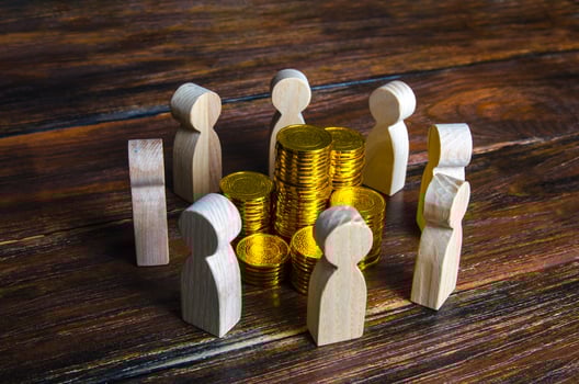 People surrounded stacks of coins. Fundraising and charity. Corporation, joint venture. Fair distribution of income among team members. Development use of budget funds. Investment groups. Corruption photo