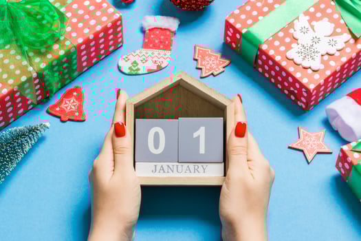 Top view of female hands holding calendar on blue background. The first of January. Holiday decorations. New Year concept photo