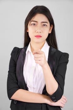 Woman in suit looking at camera and pointing finger photo