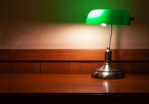 vintage lamp with green shade on wooden desk photo
