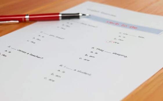 English grammar test sheet on wooden table photo