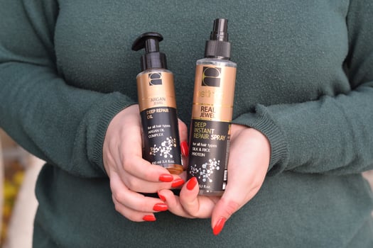 KHARKOV. UKRAINE - MAY 2, 2022 Young girl holds Estima products. Estima argan jewel deep repair oil and real jewel deep instant repair spray photo