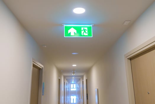 Fire Emergency exit sign on the wall background inside building. Safety concept photo