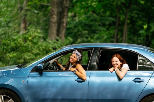 Two girlfriends fool around and laughing together in a car photo
