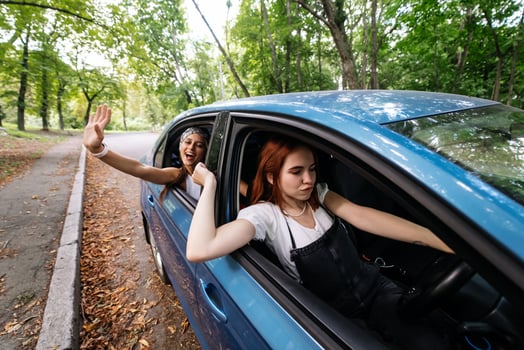 Two girlfriends fool around and laughing together in a car photo