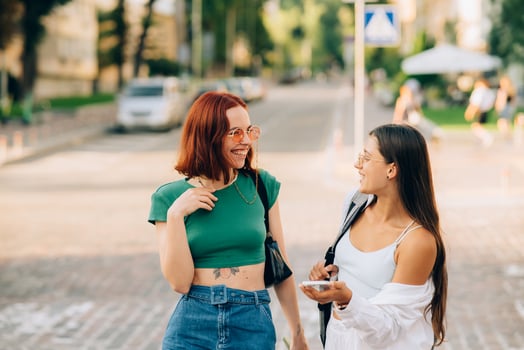 Happy women talking and laughing at the city street photo