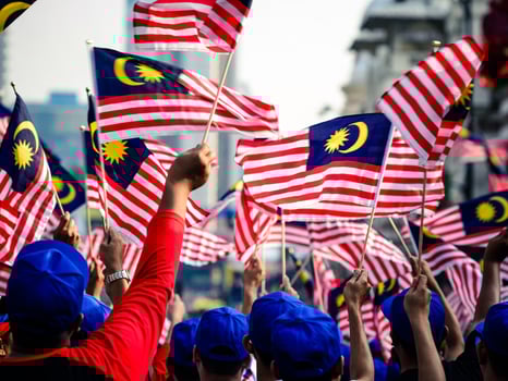 People waving Malaysian flags celebrating the independence  day photo