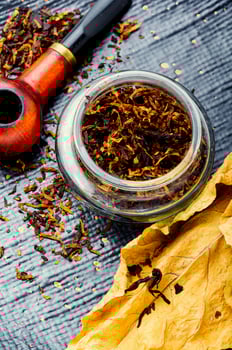 Smoking pipe with tobacco leaves photo