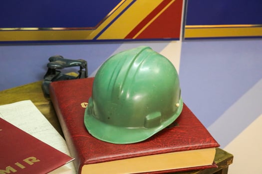 Green plastic safety helmet for the worker. Protective helmet to protect the head of people operating in hazardous conditions at the factory photo