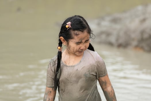 Little girls have fun playing in the mud in the community fields photo