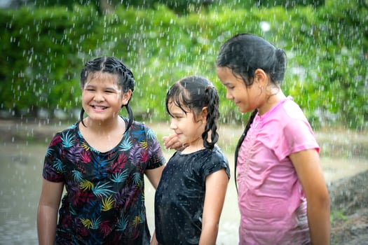 Little girls have fun playing in the mud in the community fields photo