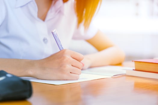 university girl hand writing. teen doing homework exam school concept. photo