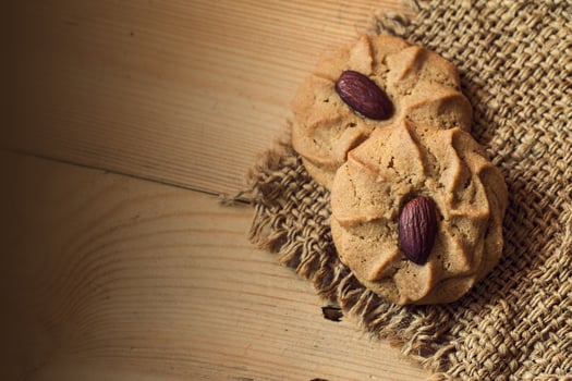 Almond Cookies with almond nuts on wooden table background with space for text photo