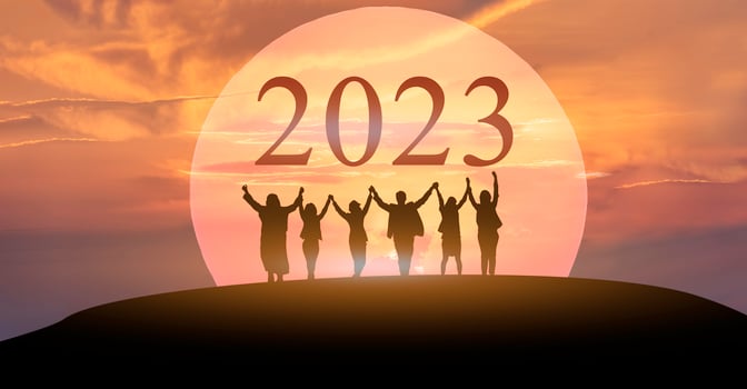 Happy new year 2023, Keep fighting together, Silhouette of 2023 letters on the mountain with business people raised arms in teamwork concept at sunrise. photo