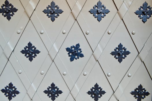 Texture of old ancient medieval gray antique sturdy iron metal door with riveting patterns. The background photo