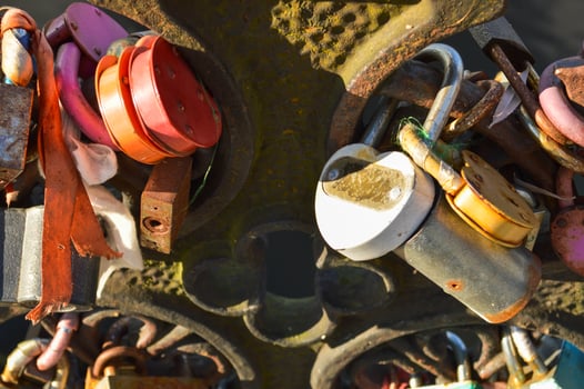 A lot of barn locks hang hitched to the bridge railing. Wedding tradition to hang locks on bridges for eternal love photo