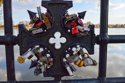 A lot of barn locks hang hitched to the bridge railing. Wedding tradition to hang locks on bridges for eternal love photo