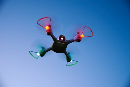 Toy drone quad copter against sunset sky photo