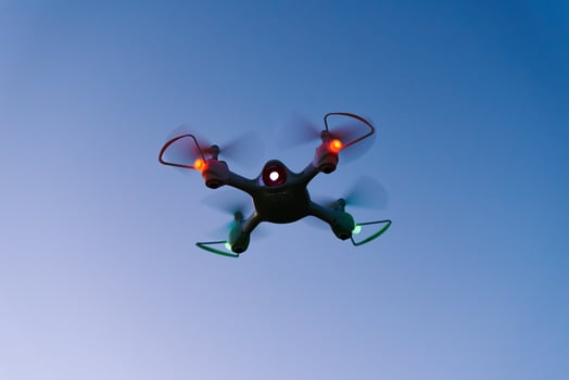 Toy drone quad copter against sunset sky photo