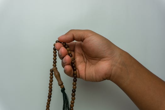 hand holding wooden tasbih beads isolated. islamic prayer beads. moslem praying concept photo
