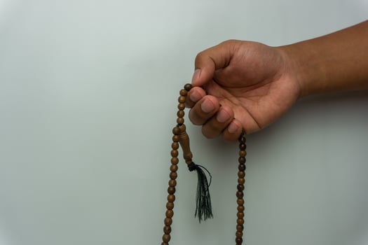 hand holding wooden tasbih beads isolated. islamic prayer beads. moslem praying concept photo