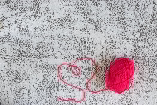 Pink yarn with love text on orange pastel background. Happy valentine concept. photo