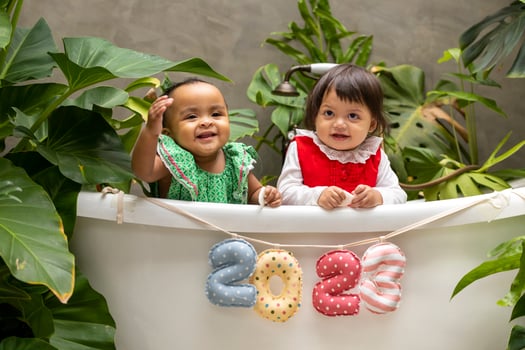 Two diversity baby toddler sitting together with 2023 happy new year sign for season celebration for happiness and kid concept photo
