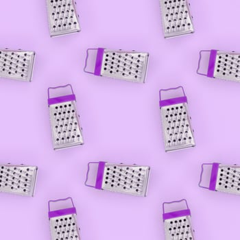 Small stainless steel graters lies on a pastel colored paper. Kitchen accessories. Tools for cooking. Flat lay top view photo