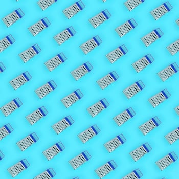 Small stainless steel graters lies on a pastel colored paper. Kitchen accessories. Tools for cooking. Flat lay top view photo