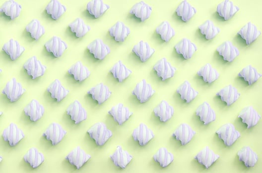 Colorful marshmallow laid out on lime paper background. pastel creative textured pattern photo